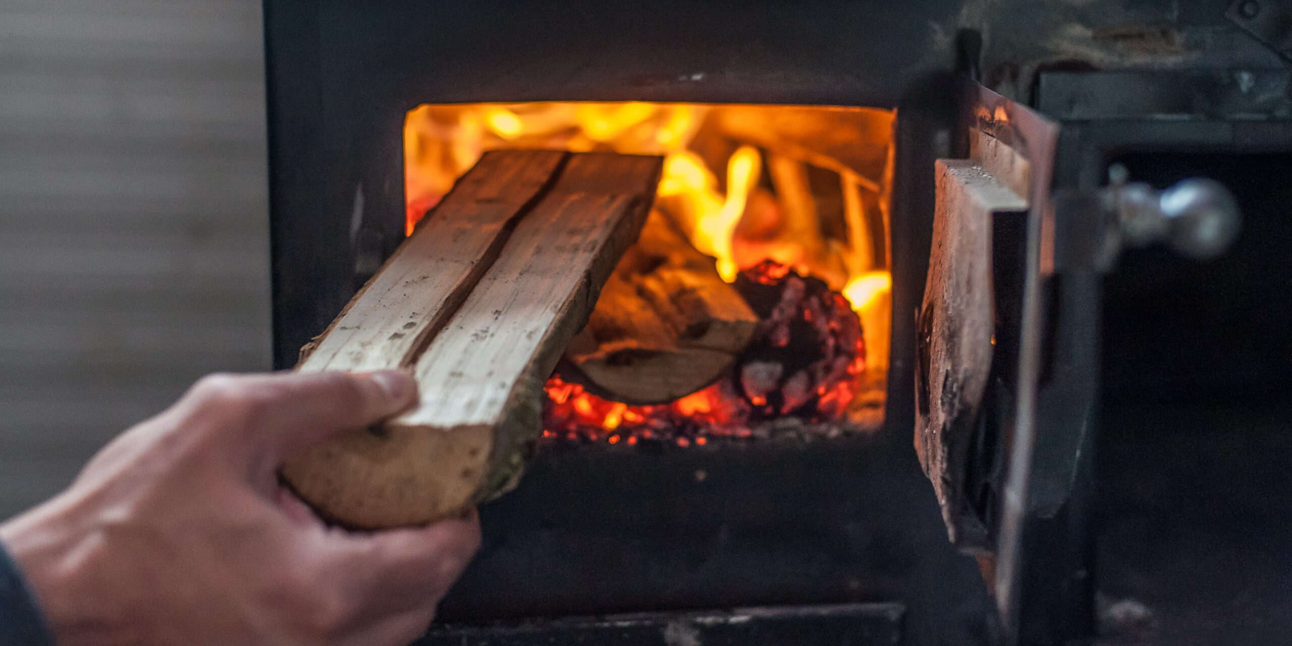 Houtblok wordt in haardvuur gegooid