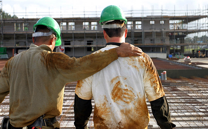 Twee bouwvakkers kijken gearmd naar bouwproject