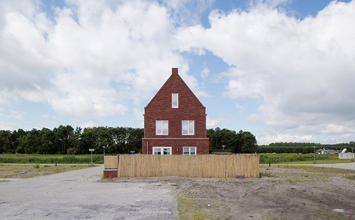 Huis op vlakte met groot hek eromheen