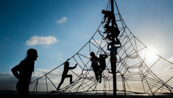 Kinderen spelen buiten in klimpiramide van touw