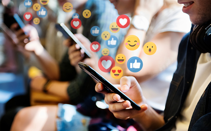 Afbeelding waarbij meerdere personen op mobiele telefoon zitten en emoticons versturen