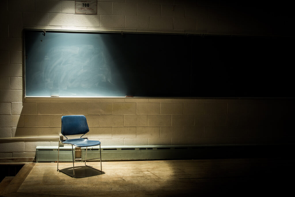 Duistere afbeelding van schoolbord met een stoel