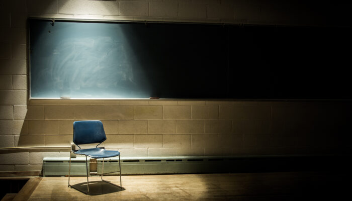 Duistere afbeelding van schoolbord met een stoel