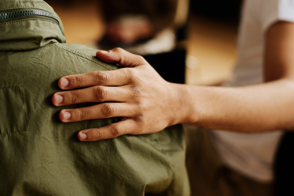 Hand op schouder van verdrietig iemand